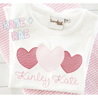 Heart Trio Sketch Stitch Embroidery Design: Three pink sketch stitch hearts above the name Kinley Kate on a white shirt