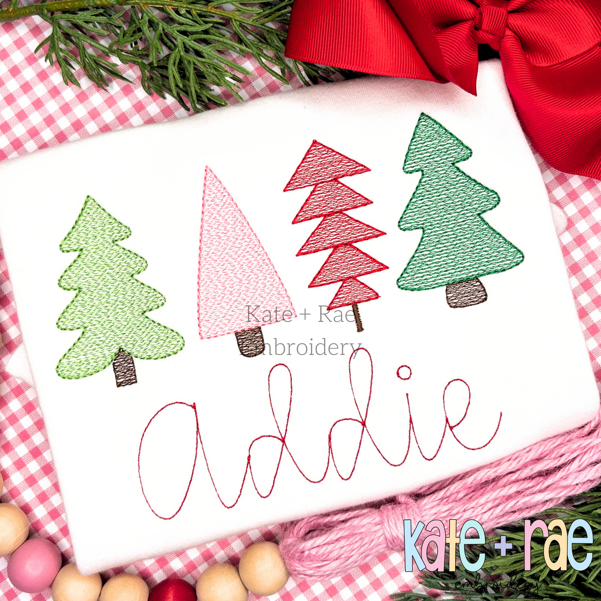 Whimsical Kiddie Christmas Tree Sketch Stitch Embroidery Design: Four whimsical Christmas trees in green, pink, and red above the name Addie in pink script on a white shirt