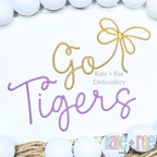 Preppy Go Tigers Embroidery Design: The words Go Tigers in gold and purple script with a gold bow on white fabric
