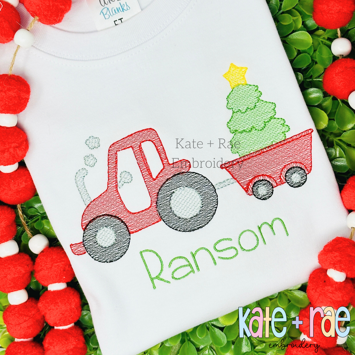 Tractor with Christmas Tree in Wagon Sketch Stitch Embroidery Design: Red tractor pulling a wagon with a Christmas tree above the name Ransom in green on a white shirt