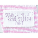 Summer Nights Bean Stitch Embroidery Font: The words Summer Nights Bean Stitch Font stitched in purple on white fabric over pink seersucker