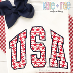 USA Star Filled Embroidery Design: The word USA in red star print collegiate applique letters with a navy outline on a white shirt