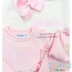 Dottie Satin Stitch Applique Embroidery Font: The name annie in pink satin applique letters on a pink sweater with a matching hat