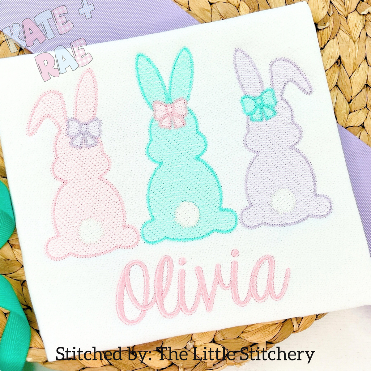 Girl's Easter Bunny Trio Sketch Stitch Embroidery Design: Pink, mint, and lavender sketch stitch bunnies with bows above the name Olivia in pink script on a white shirt