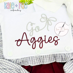 Preppy Satin Stitch Embroidery Font: The words Go Aggies in gray and maroon preppy script with a bow on a white shirt