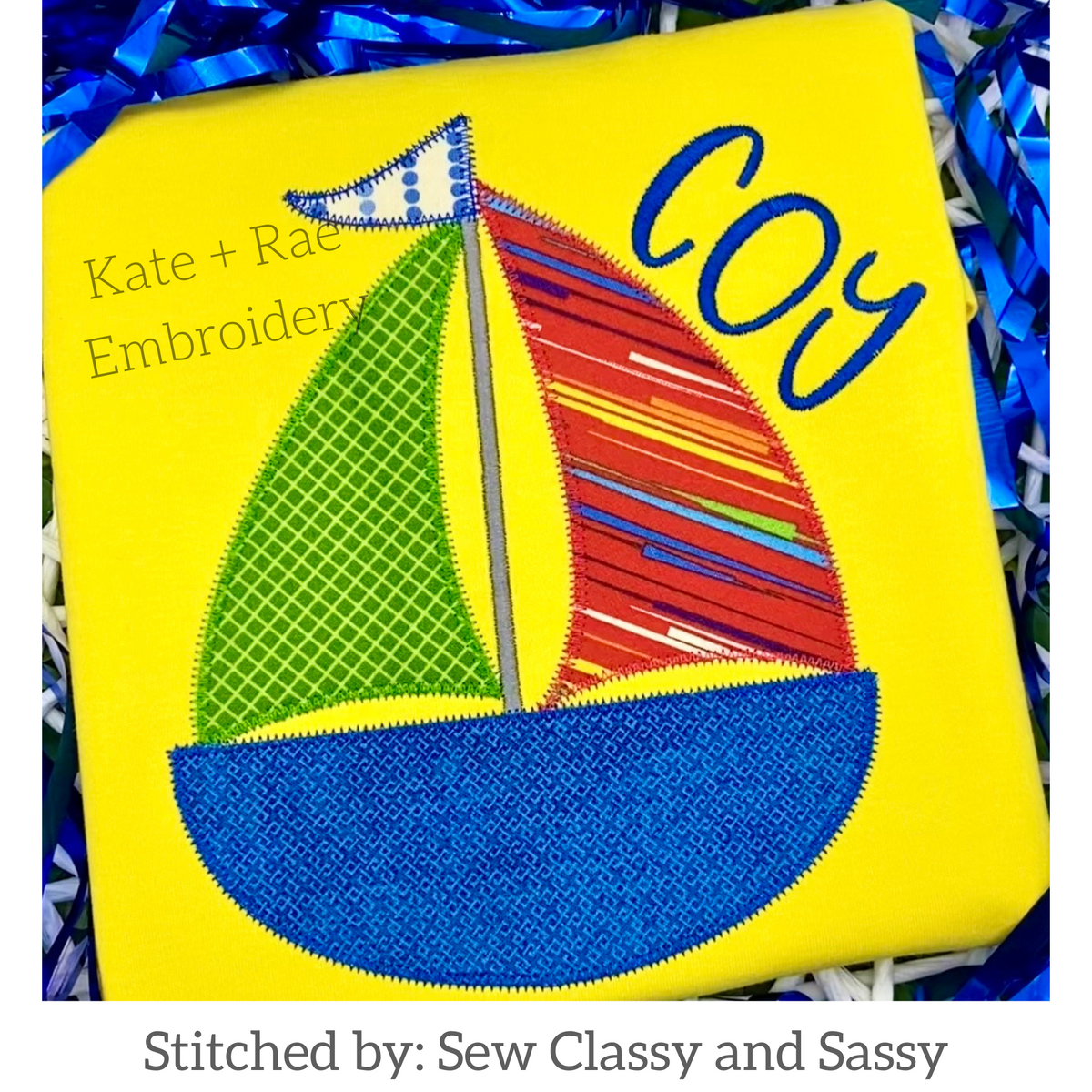 Boy's Sailboat Zigzag Applique Embroidery Design: Sailboat applique with green and striped sails and a blue hull beside the name Coy on a yellow shirt