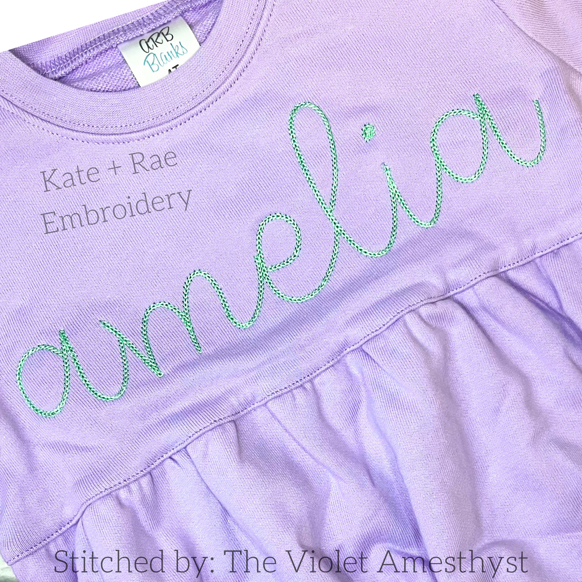 Hello Chain Stitch Embroidery Font: The name amelia in green chain stitch script on a lavender ruffled shirt