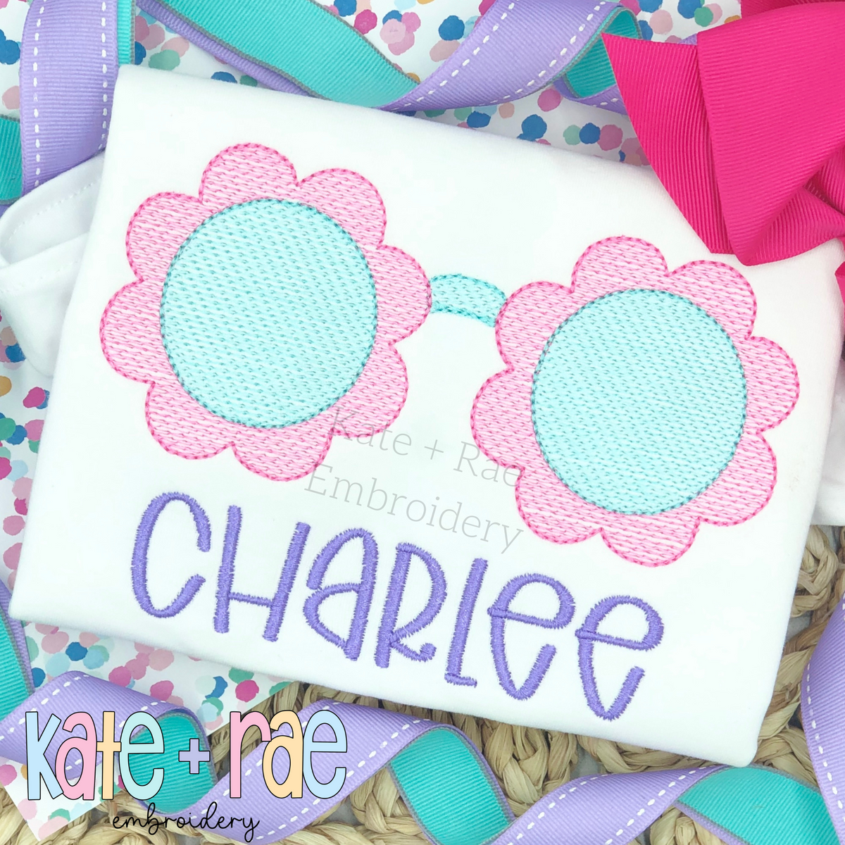 Flower Sunglasses Sketch Stitch Embroidery Design: Sketch stitch flower shaped sunglasses with pink frames above the name Charlee in purple on a white shirt