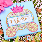 Pumpkin Carriage Zigzag Applique Embroidery Design: Pumpkin carriage applique with a pink crown and the name rylee on a light blue shirt