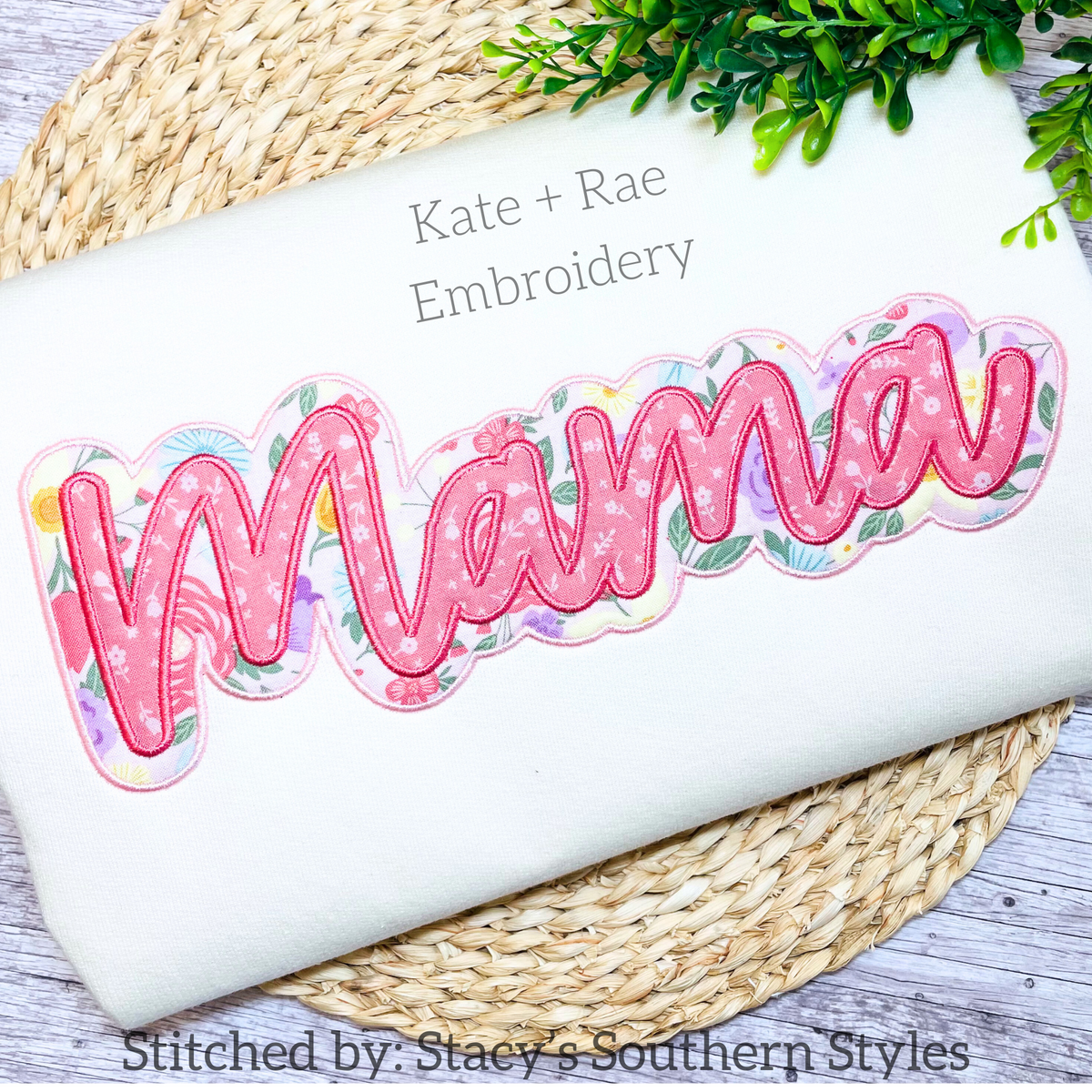 Mama Script Double Satin Stitch Applique Embroidery Design: The word Mama in pink script with a floral print double applique outline on a white sweatshirt