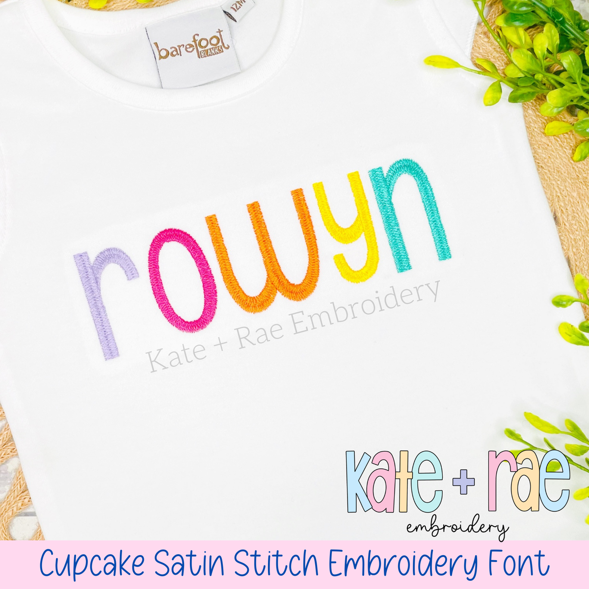Cupcake Satin Stitch Embroidery Font: The name rowyn in rainbow satin stitch letters on a white shirt