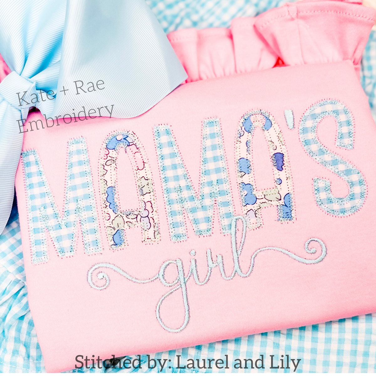 Kinley Zigzag Stitch Applique Embroidery Font: The words Mama's girl in blue gingham applique letters with floral fill on a pink shirt