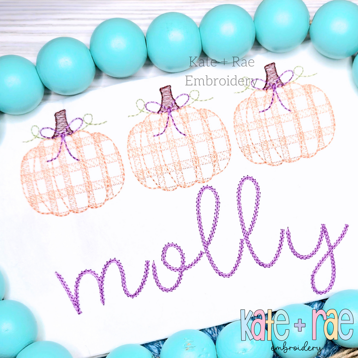 Girl's Plaid Filled Pumpkins with Bows Sketch Embroidery Design: Three peach plaid pumpkins with bows above the name molly in purple script on a white shirt