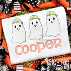 Boy's Ghost Trio Sketch Stitch Embroidery Design: Three sketch stitch ghosts wearing green caps above the name Cooper in orange on a white shirt