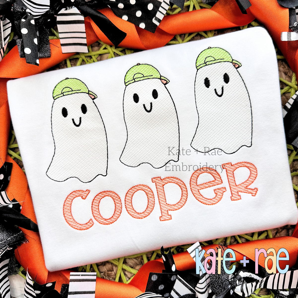 Boy's Ghost Trio Sketch Stitch Embroidery Design: Three sketch stitch ghosts wearing green caps above the name Cooper in orange on a white shirt