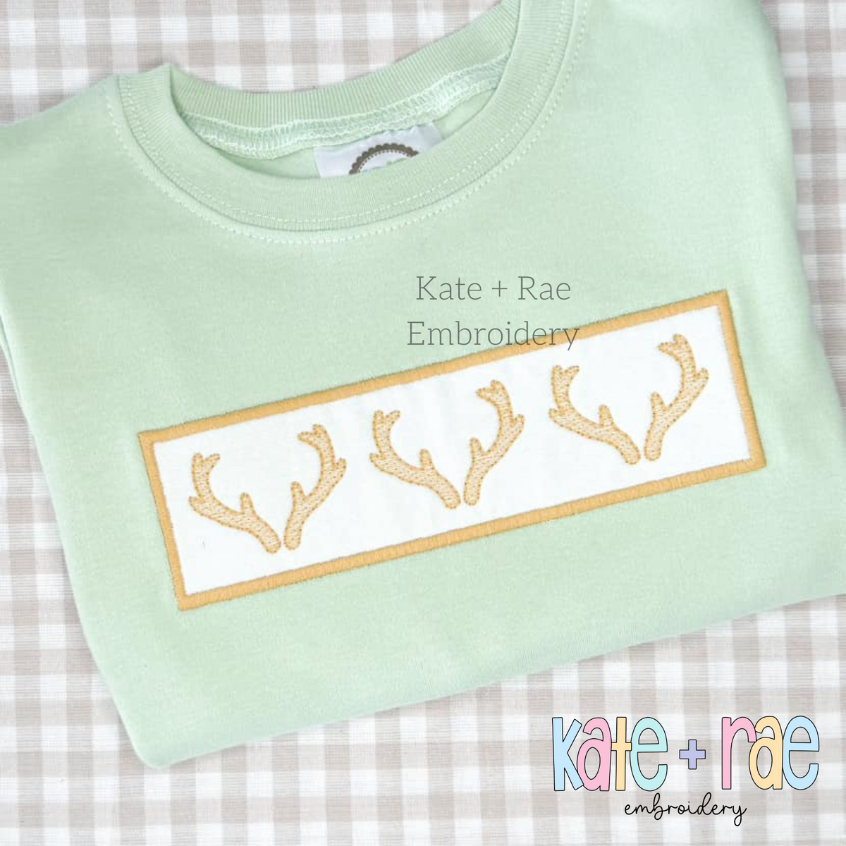 Deer Antler Sketch Stitch with Satin Applique Patch Embroidery Design: Three tan deer antlers on a satin applique patch on a mint shirt