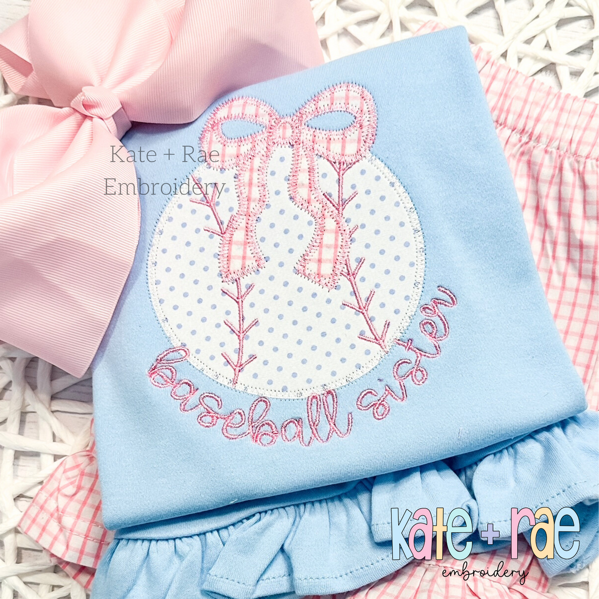 Baseball/ Softball with Merritt Bow Zigzag Stitch Embroidery Design: Baseball applique with a pink gingham bow above the words baseball sister in pink on a light blue shirt