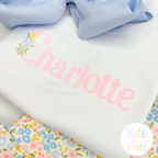 Floral Block Sketch Stitch Embroidery Font: Close-up of Charlotte in pink sketch letters with a tiny flower bouquet