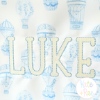 Jellybean Fill Stitch with Bean Border Machine Embroidery Font: Close-up of LUKE in cream Jellybean fill stitch with blue bean border on hot air balloon fabric