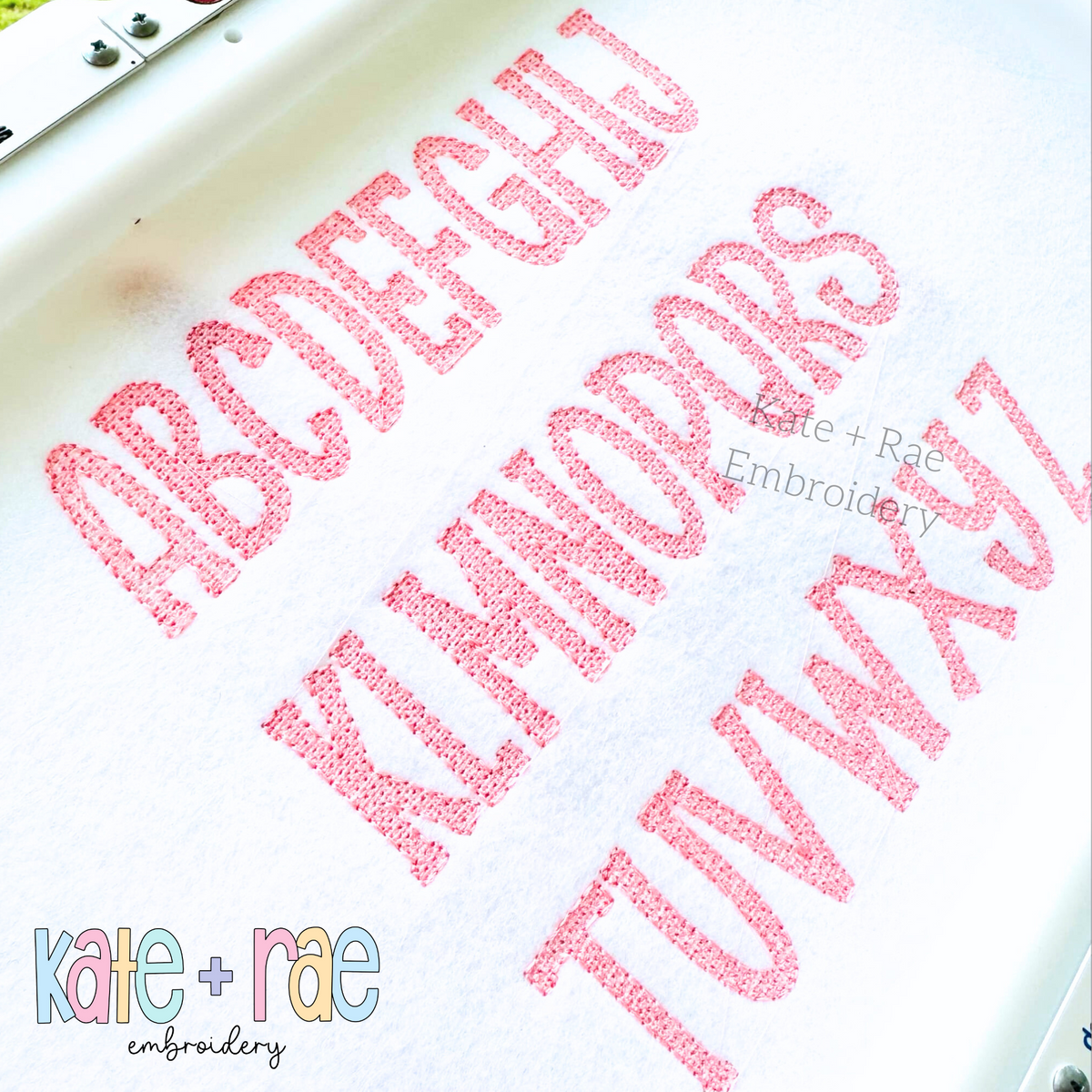 Gracie Faux French Knot Motif Fill Stitch Embroidery Font: Uppercase alphabet stitched in pink faux French knot letters on white fabric