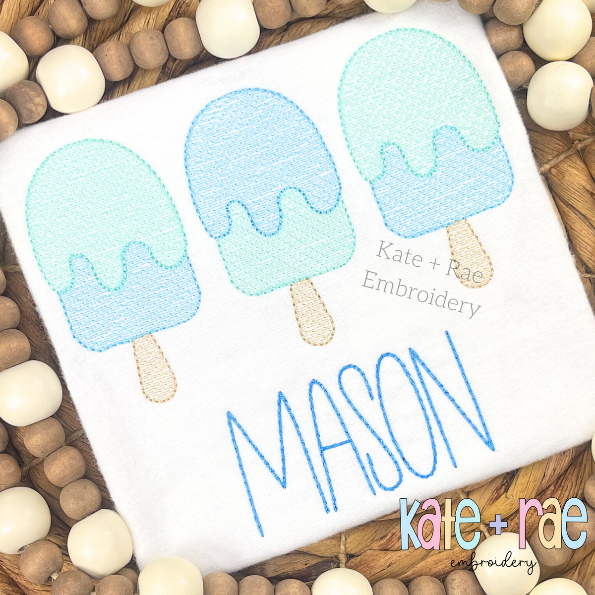 Boy's Summer Popsicle Trio Textured Sketch Stitch Embroidery Design: Three blue and mint textured sketch popsicles above the name MASON in blue on a white shirt