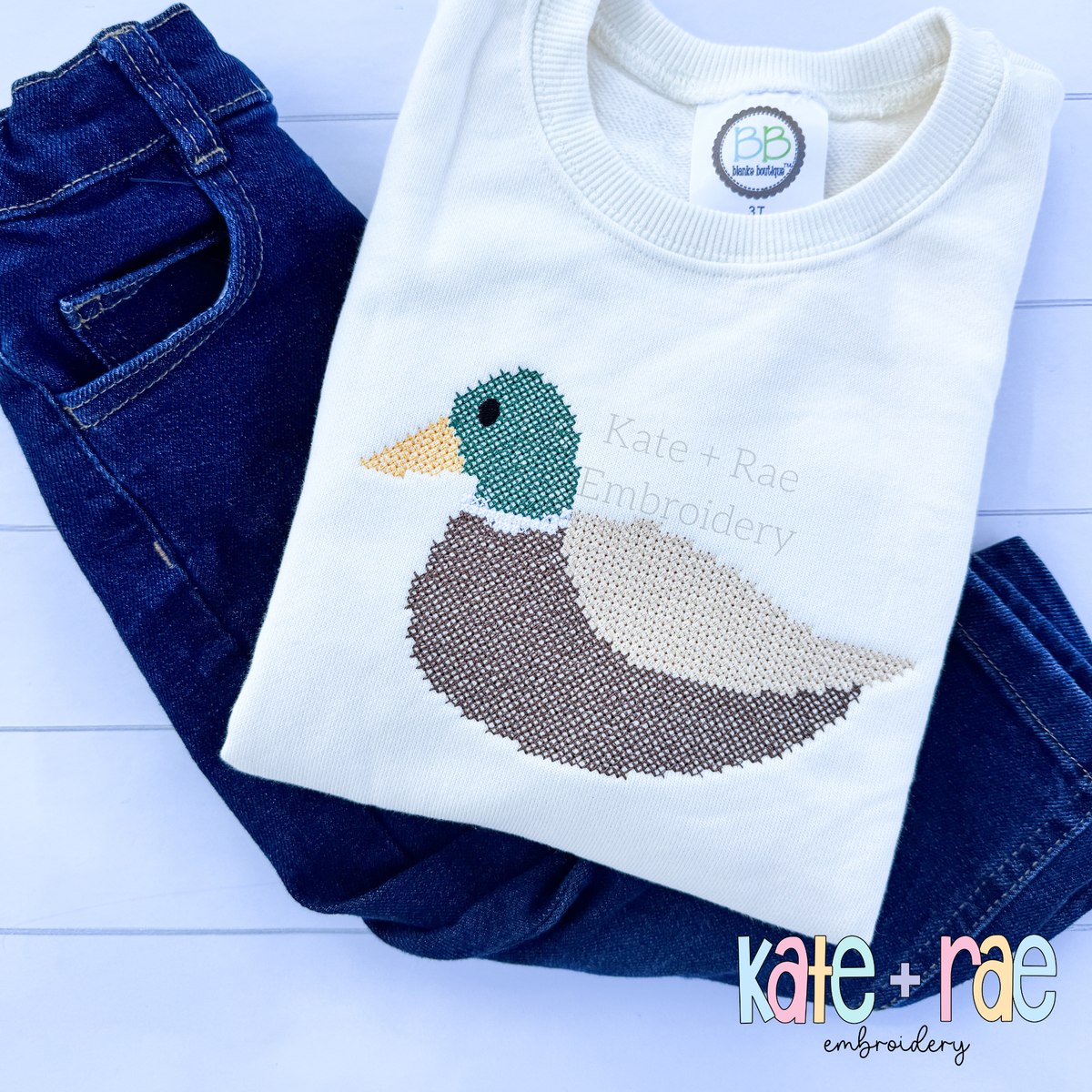 Mallard Duck Cross Stitch Embroidery Design: Mallard duck cross stitch on a cream sweatshirt with jeans