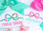 Flowy Longtail Bow Satin Stitch Applique Embroidery Design: Two shirts with bright print flowy bow appliques named mary clarke and Josephine