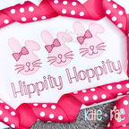 Three pink sketch bunnies with bows above Hippity Hoppity in pink sketch lettering on a white shirt