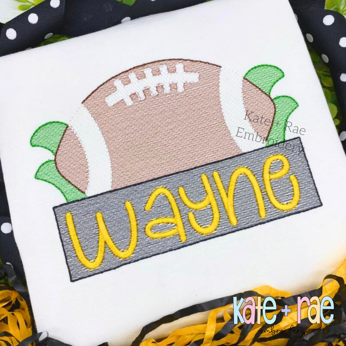 Football with Name Plate Sketch Stitch Applique Embroidery Design: Sketch stitch football above a gray name plate reading Wayne in yellow on a white shirt