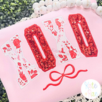Curved XOXO with Bow Satin Stitch Applique Embroidery Design: The word XOXO in red sequin and floral curved collegiate applique letters with a red bow on a pink sweatshirt
