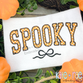 Curved Spooky with Bow Zigzag Stitch Applique Embroidery Design: SPOOKY in orange polka dot zigzag applique letters with a black bow on a white shirt