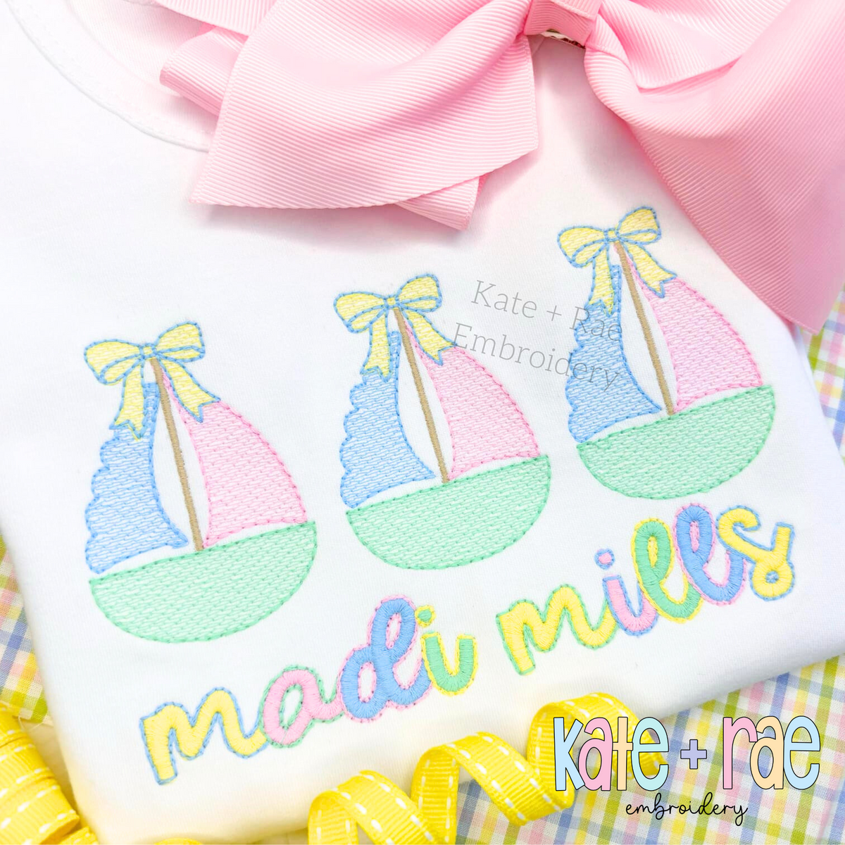 Sailboat Trio with Bows Sketch Stitch Embroidery Design: Three pastel sketch sailboats with yellow bows above the name madi mills in pastel letters on a white shirt
