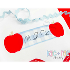 Apple Name Frame Zigzag Applique Embroidery Design: Close-up of red apple appliques on each side of a blue gingham name plate