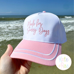 Made for Sunny Days: White and pink trucker hat with Made for Sunny Days held at the ocean