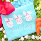 Girl's Easter Bunny Trio Sketch Stitch Embroidery Design: Three white sketch bunnies with pink bows above the name Macy in pink script on a light blue shirt