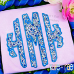 Scalloped Monogram Zigzag Stitch Applique Embroidery Font: Blue floral scalloped zigzag applique monogram on a lavender shirt