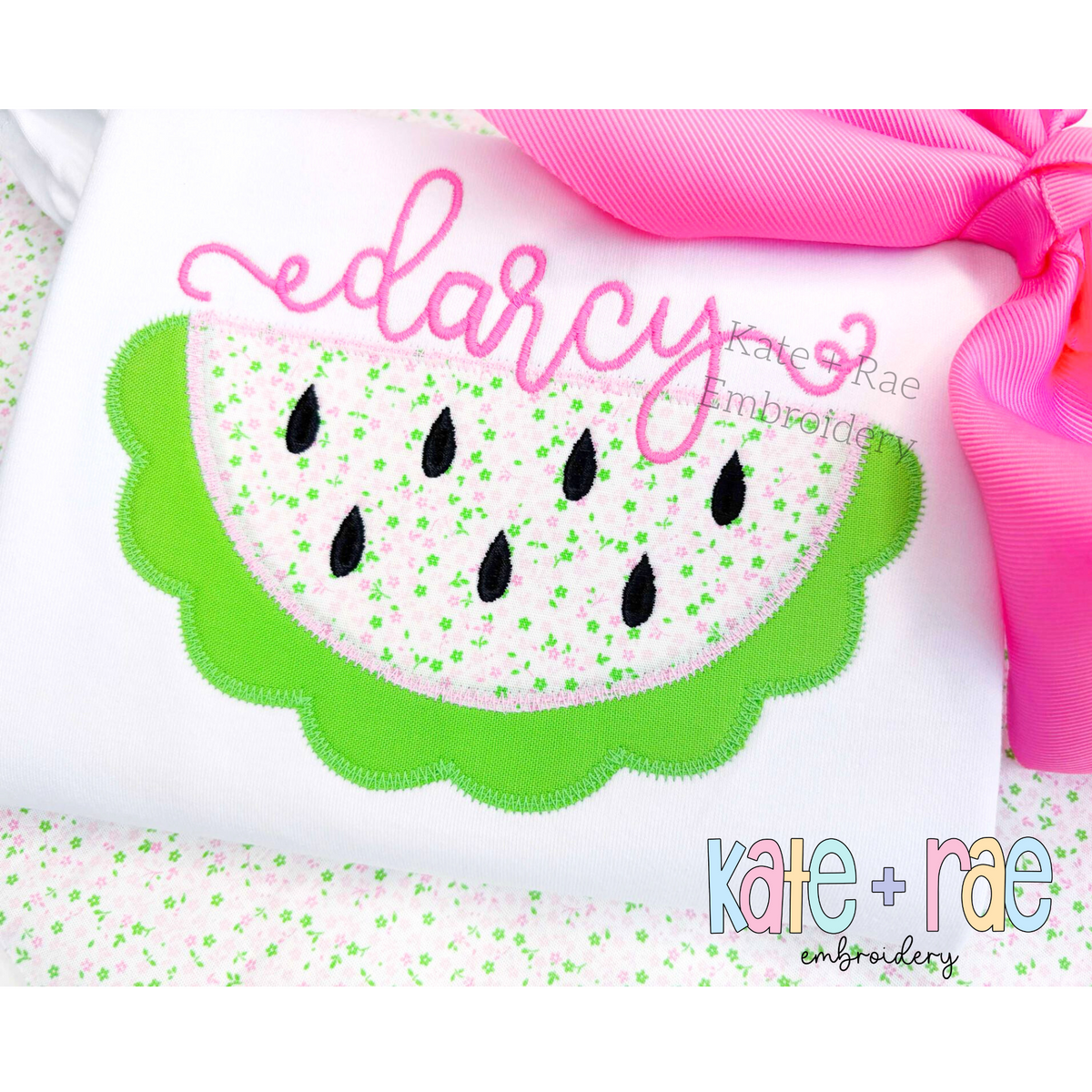 Watermelon Zigzag Applique Embroidery Design: Scalloped watermelon applique below the name darcy in pink script on a white shirt with a pink bow