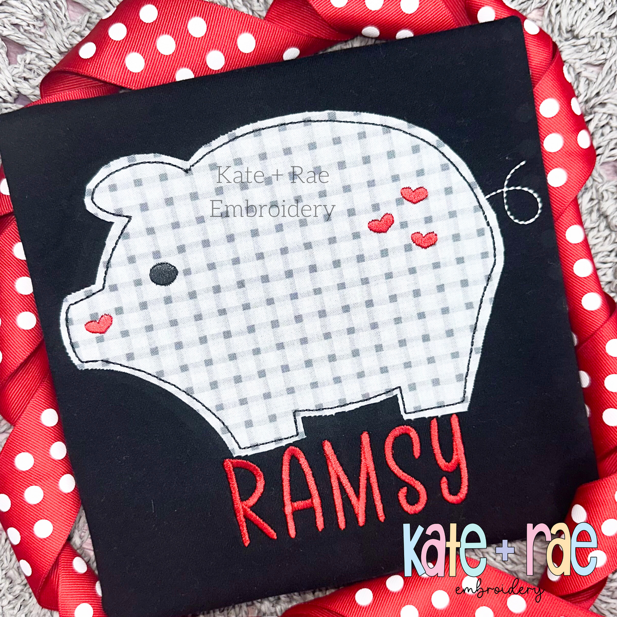 Heart Piggy Bean Stitch Applique Embroidery Design: Gray gingham pig applique with red hearts above the name RAMSY in red on a black shirt