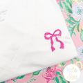 Merritt Bow MINI Cross Stitch Embroidery Design: Small pink cross stitch bow on a white tee