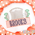 Football with Name Plate Sketch Stitch Applique Embroidery Design: Sketch stitch football above an orange name plate reading BROOKS in navy on a white shirt
