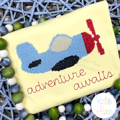Airplane Cross Stitch Embroidery Design: Cross stitch airplane above adventure awaits in red script on a yellow shirt
