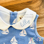 Hello Bean Stitch Embroidery Font: The name lilly in light blue script stitched on the white collar of a blue sailboat print dress