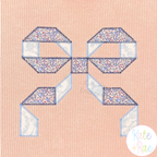 Quilt Block Bow 2 Zigzag Applique Embroidery Design: Blue floral and white quilt block bow applique on a peach corduroy shirt