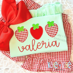 Strawberry Trio Zigzag Applique Embroidery Design: Three gingham and red strawberry appliques above the name valeria in red script on a mint shirt