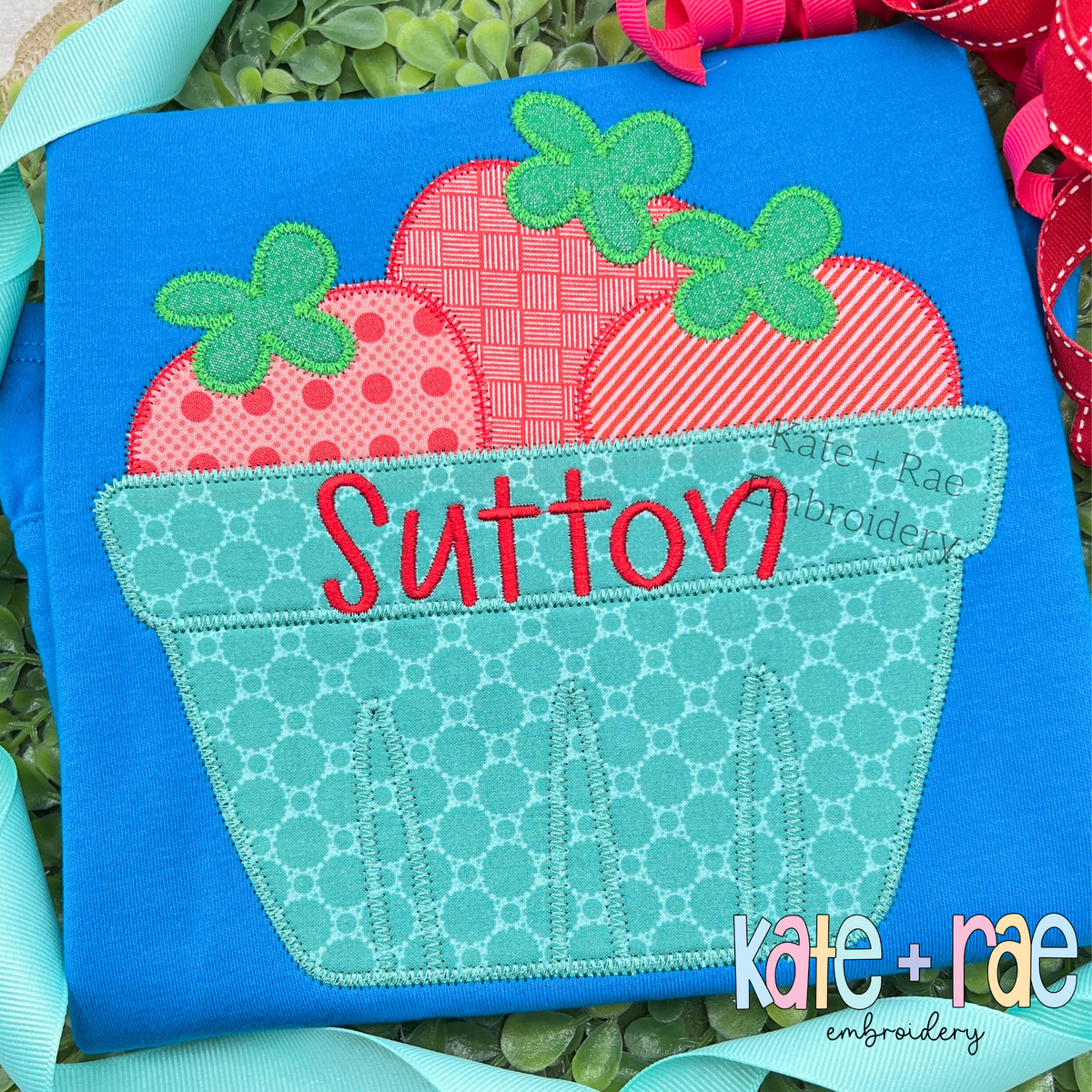 Strawberry Basket Zigzag Applique Embroidery Design: Strawberry basket applique with patterned berries and the name Sutton in red on a blue shirt