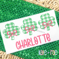 Plaid Shamrock Trio with Bows Sketch Stitch Embroidery Design: Three green gingham shamrocks with pink bows above the name CHARLOTTE in pink on a white shirt