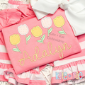 Tulip Party Satin Stitch Applique Embroidery Design: Five pastel tulip appliques above the name Adalyn in yellow script on a coral shirt