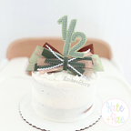 One Half Satin Stitch Applique Embroidery Design: Green gingham one half cake topper with ribbon bows on a white smash cake