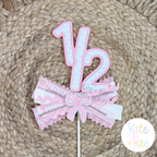 One Half Satin Stitch Applique Embroidery Design: Pink gingham one half cake topper with pink ribbons and a bow