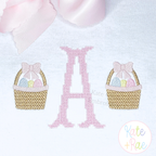 Girl's Simple Easter Basket Mini Fill Embroidery Design: Pink cross stitch monogram letter A between two small Easter baskets with pink bows on white fabric